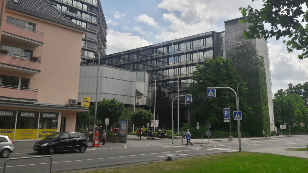 Das Kreishaus in Siegburg. Davor eine Straße mit Fußgängerüberweg und etwas Grünfläche.